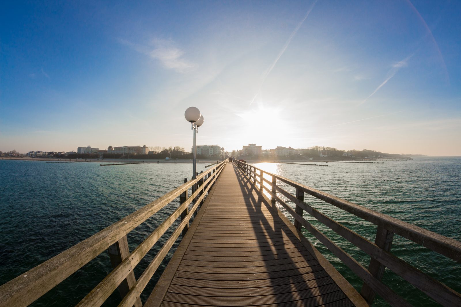 Abendsonne über der Seebrücke Kühlungsborn, das Geländer führt aufs Wasser hinaus